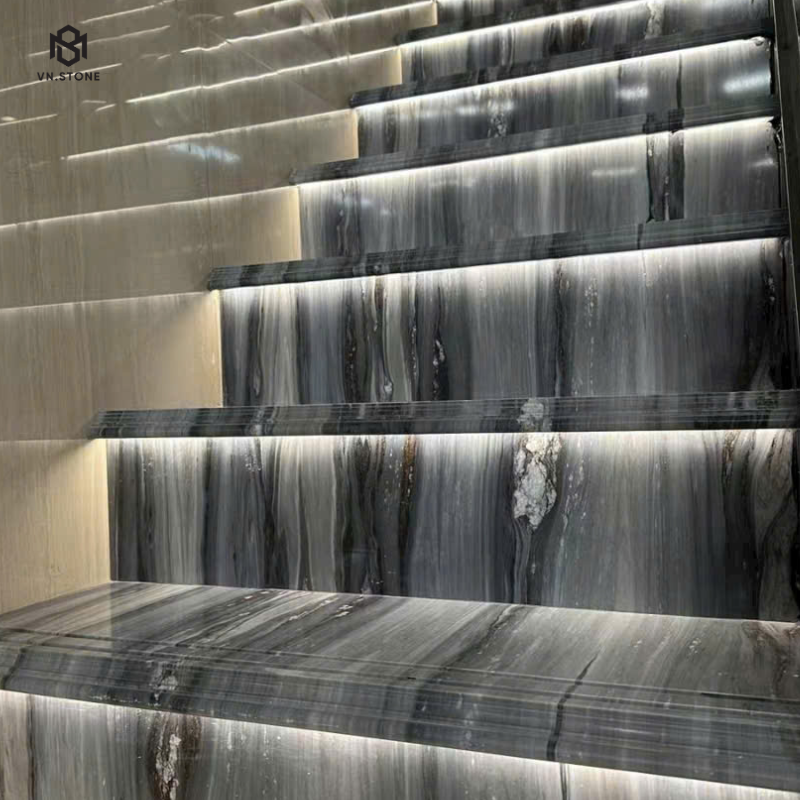 Cận cảnh mặt bậc marble xám vân sóng còn giữ độ bóng gương, đèn LED âm hắt sáng dưới mũi bậc và cổ bậc ốp cùng loại đá